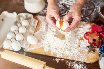 Skilled cook adding an egg to a pile of flour