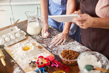 Obraz na płótnie Canvas Two busy cooks preparing to make dough in kitchen