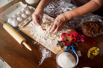 Hands of skillful cook mixing dough ingredients