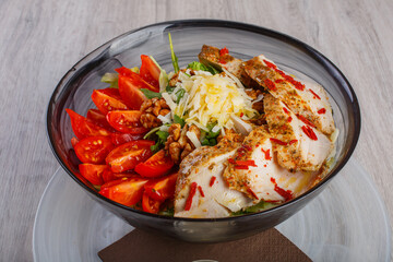 Tagliata di pollo speziato cotto a bassa temperatura con insalata, noci, formaggio e pomodori