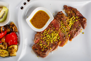 Tagliata di carne cotta al sangue e guarnita con granella di pistacchio