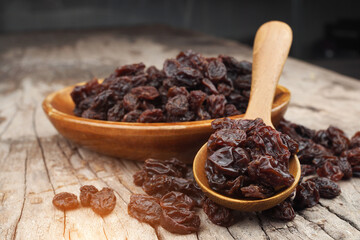 Organic dried raisins in wood spoon on vintage old wooden table, Currant