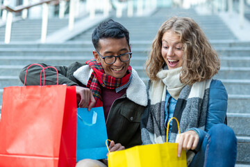 a young woman looks with an air of surprise the gift just received from her boyfriend, couple of...