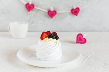 Pavlova cake on the background of hearts. Valentine's Day. Selective focus.