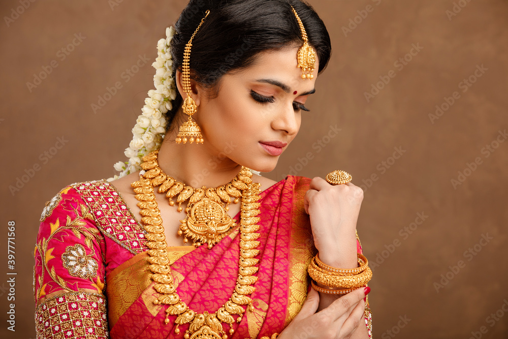 Wall mural beautiful indian young hindu bride against brown background in studio shot