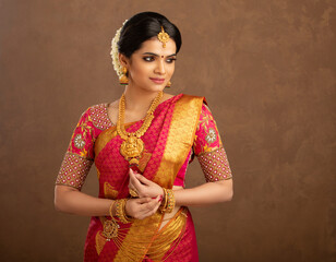 Beautiful Indian young Hindu Bride against brown background in studio shot - obrazy, fototapety, plakaty