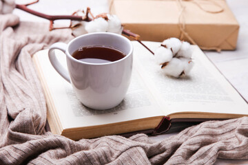 Cup of hot tea and open book