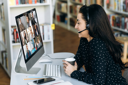 Successful caucasian woman manager or call center worker in headphones communicates online by video conference with her colleagues or clients about important working moments
