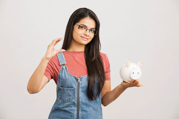 Young Woman Saves Money in Piggy bank on white
