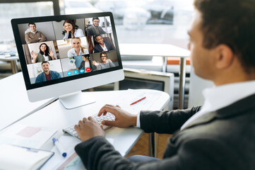 Online video meeting. Successful young adult businessman communicate with  business colleagues by...