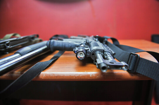 Shallow depth of field (selective focus) image with the flashlight and muzzle of an assault rifle.