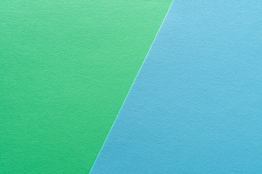 Paper texture background of pastel green and blue colors. Sheets of blank light green and light blue paper with fine texture devided  by a sloping border.