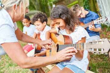 Gruppe Kinder lernt Gitarre spielen im Sommercamp
