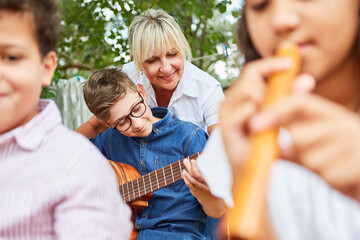 Lehrerin und Kinder zusammen im Musik Unterricht