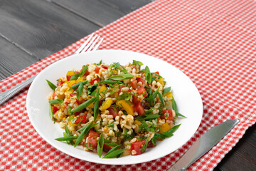 Georgian Tabbouleh salad with bulgur and vegetables on black wooden table