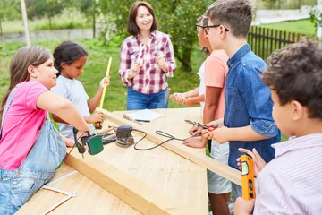 Foto op Plexiglas Kinder und Lehrerin werken mit Holz im Workshop © Robert Kneschke