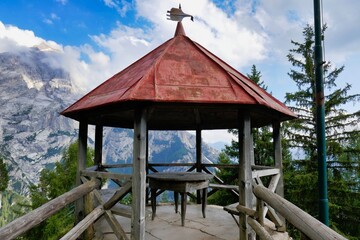 gazebo in the park, photo as a background , in dolomites mountains, autumn in italy