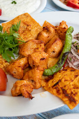 chicken shish kebab in a plate with appetizers