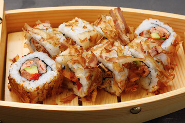 Sushi roll with tuna shavings on plate close up