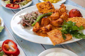 chicken shish kebab in a plate with appetizers