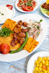meat shish kebab in a plate with appetizers