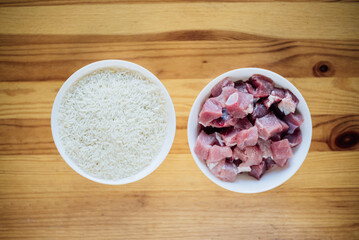 ingredients for pilaf - rice and meat on a wooden table