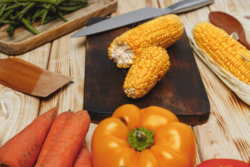 Cobs of corn on wooden cutting board