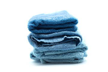 Closep of blue bath towels pile on white background