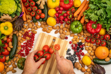 A cook who is cutting vegetables on a white wooden table