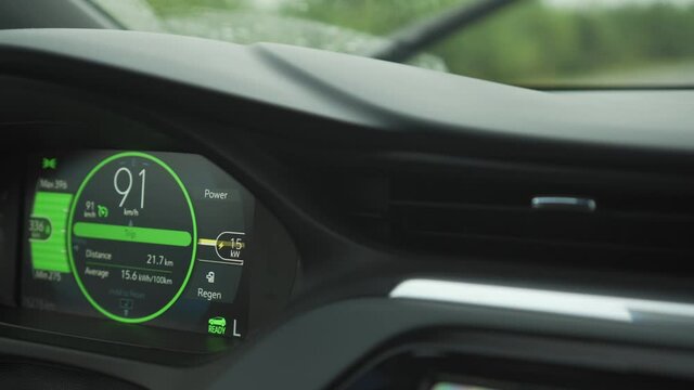 Electric car vehicle dashboard view during driving at 90 kilometers per hour speed. Power consumption. Battery recuperation and regeneration sign