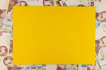 Yellow paper on a background of 1000 UAH or Ukrainian Hryvnia banknotes. Financial setup for mock-ups with your identity.