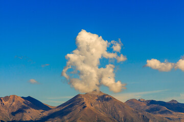 Curious shaped clouds on top of a mountain. Nature elements concept
