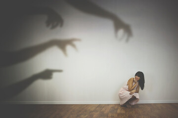 woman frightened by the shadows of hands of demons - 397779171