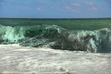 A wave crashing onto the shore with foam. Seascape
