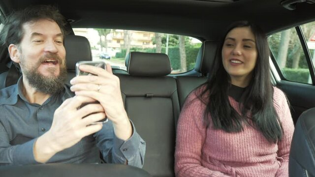 Man and woman happy after end of quarantine playing in uber car making funny faces