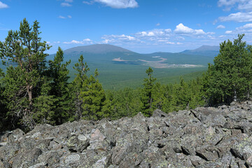 Fototapeta na wymiar Northern Ural Mountains, View from the slope of Third Bugor Mount on Kosvinsky Rock Mount and Kytlym settlement, Russia