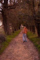 Obraz premium man with a yellow hoodie walking in the woods