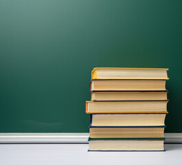 blank green chalk school board and stack of books, back to school