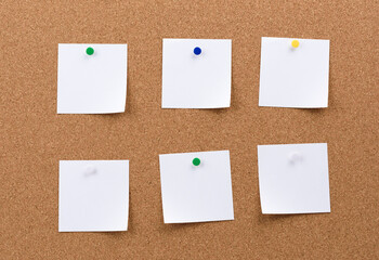 white square blank pieces of paper pinned on a cork board