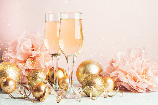 Champagne glass goblets gold balloons serpentine pastel delicate pink background