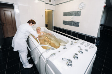 the procedure of underwater shower massage in the bathroom.Girl on the procedure of underwater massage - obrazy, fototapety, plakaty