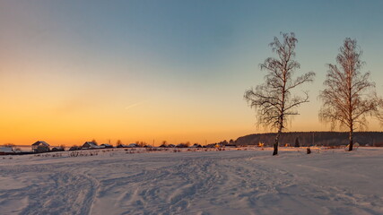 Winter sunset on the background of the village