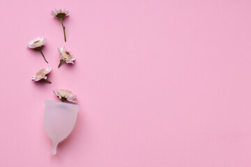 Menstrual cup with flowers on pink background