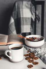 Homemade granola with figs, berries, honey. Cup of coffee and coffee pot. Breakfast.