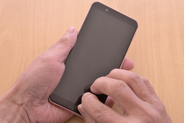 スマートフォンを操作するシニアの手