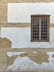 Window with an old iron grille on a wall