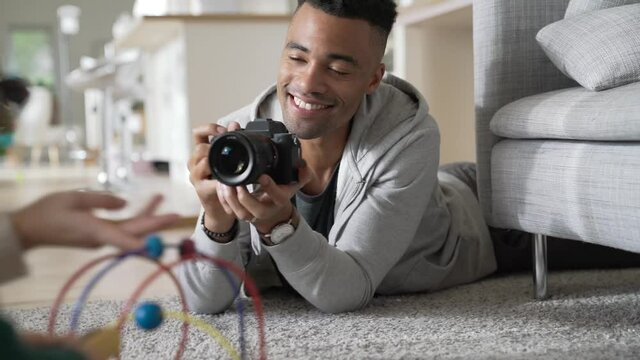 Young man taking pictures of his baby girl