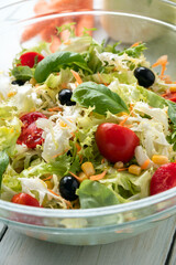 Insalata mediterranea con lattuga, pomodoro, mais, olive, carota, basilico e olio extra vergine di oliva 