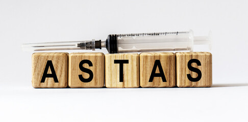 Text ASTAS made from wooden cubes. White background