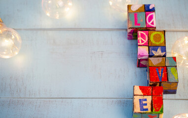 rebus cubes, with the encrypted word love, made at home, on a wooden blurred background